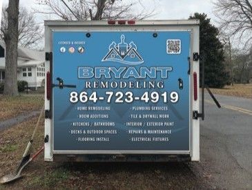 Blue Bryant Remodeling trailer with logo, phone number, and service list in a yard