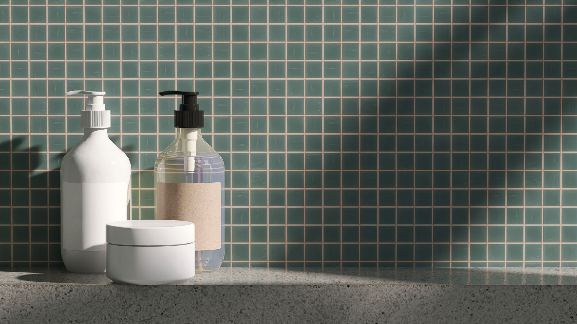A contractor installing a shower head after putting grey hexagon tiles on a bathroom wall.