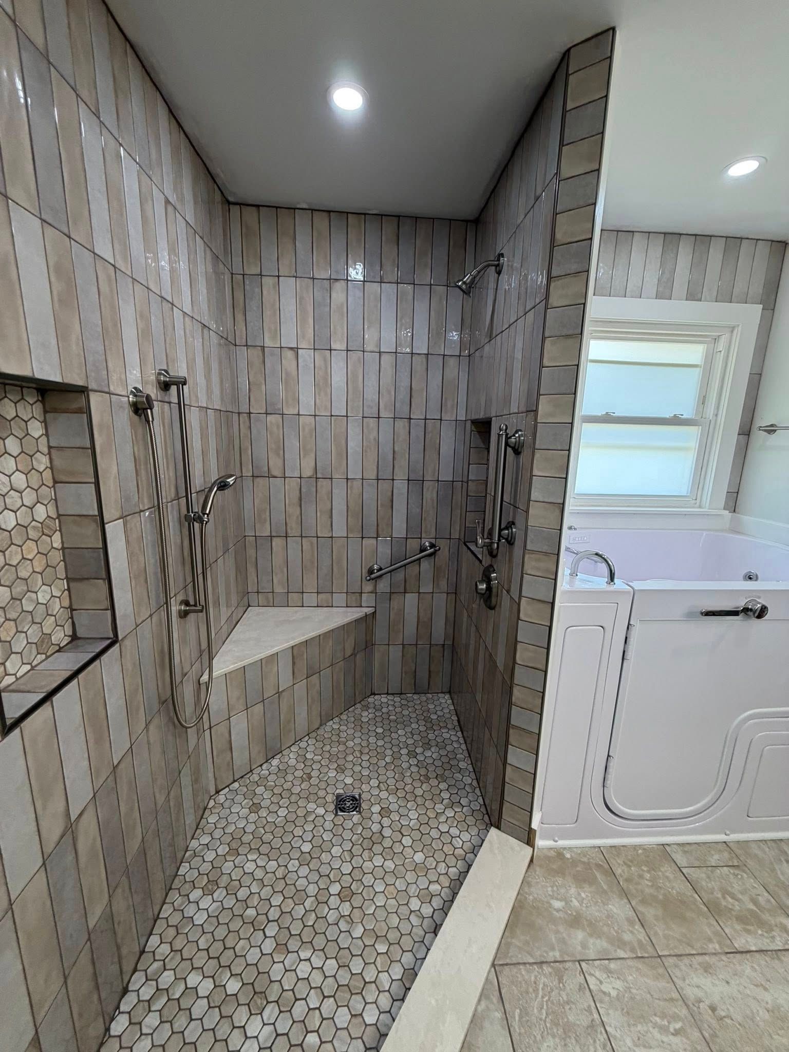 Tiled walk-in shower with built-in bench, glass partition, and rainfall showerhead.