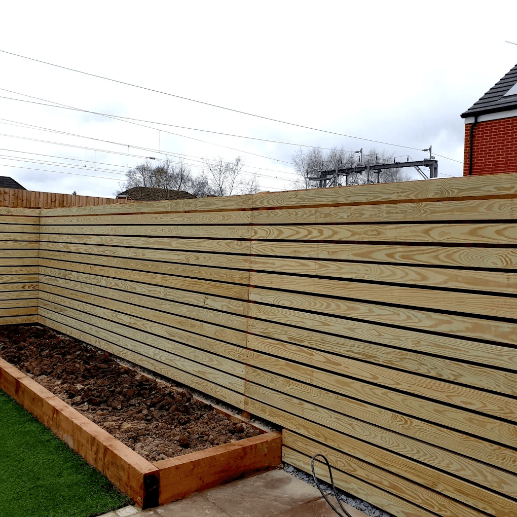 Horizontal timber board fencing turning a corner beside a raised garden bed in Bracknell.