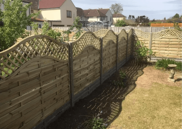 Timber garden fence panels with curved lattice trellis tops along a garden boundary in Reading.
