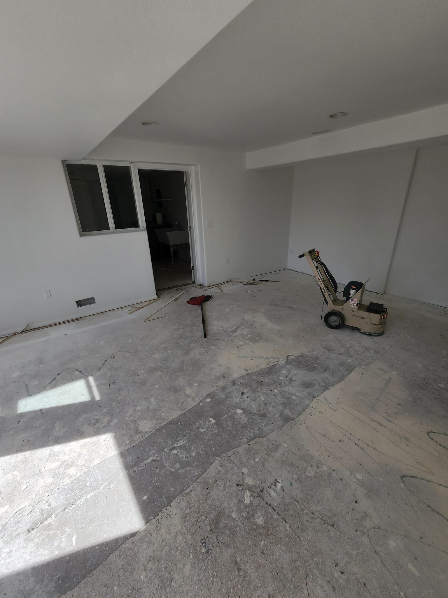 A room with a hammer and a machine on the floor.