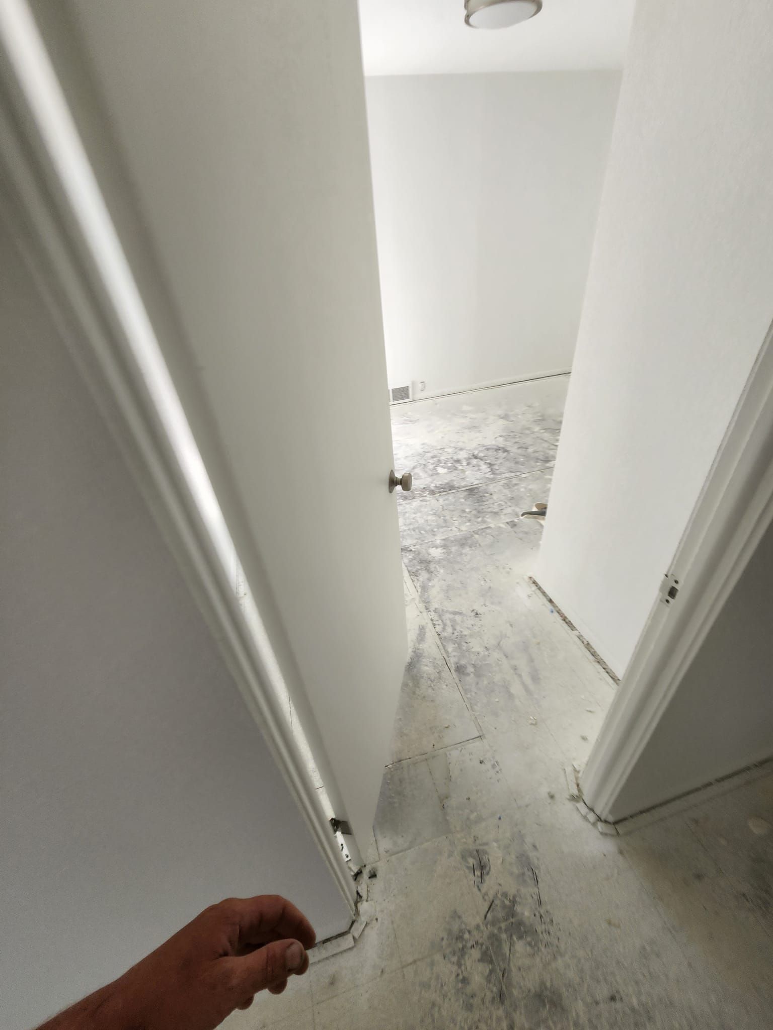 A person is opening a door in a hallway.