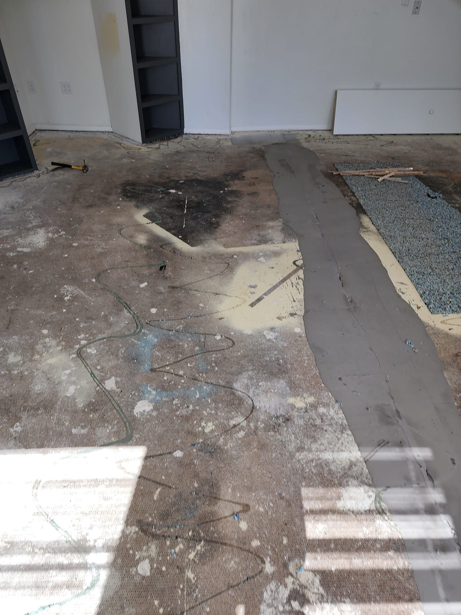 A room with a lot of dirt on the floor and a ladder.