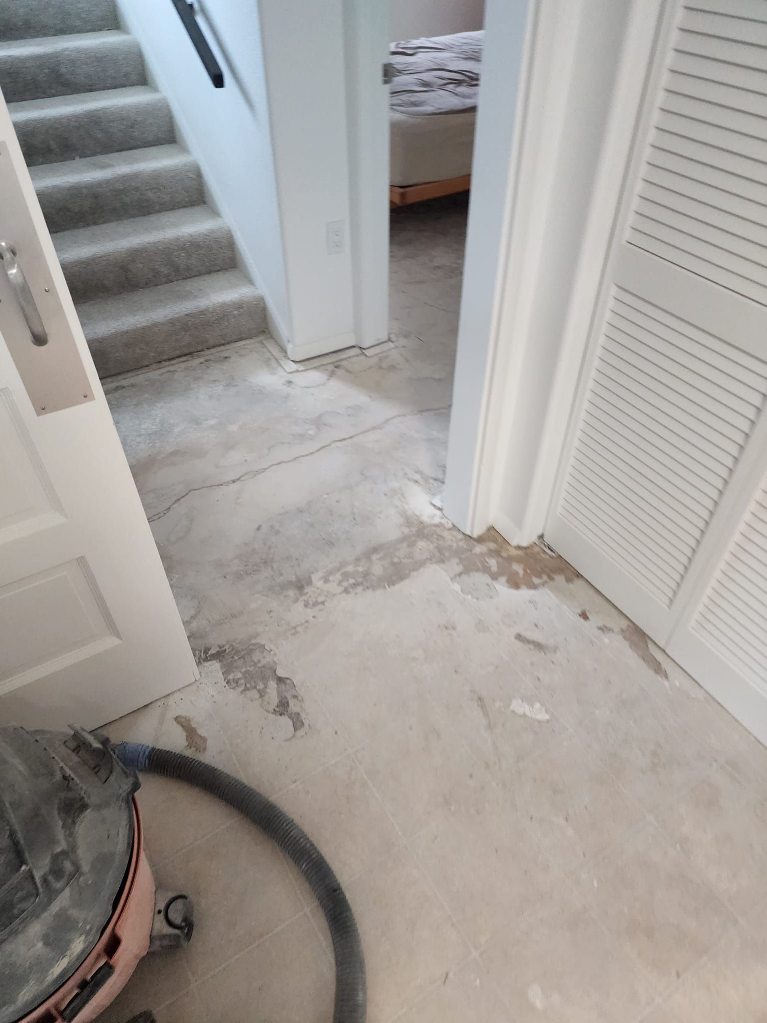 A vacuum cleaner is sitting on the floor of a room next to a staircase.