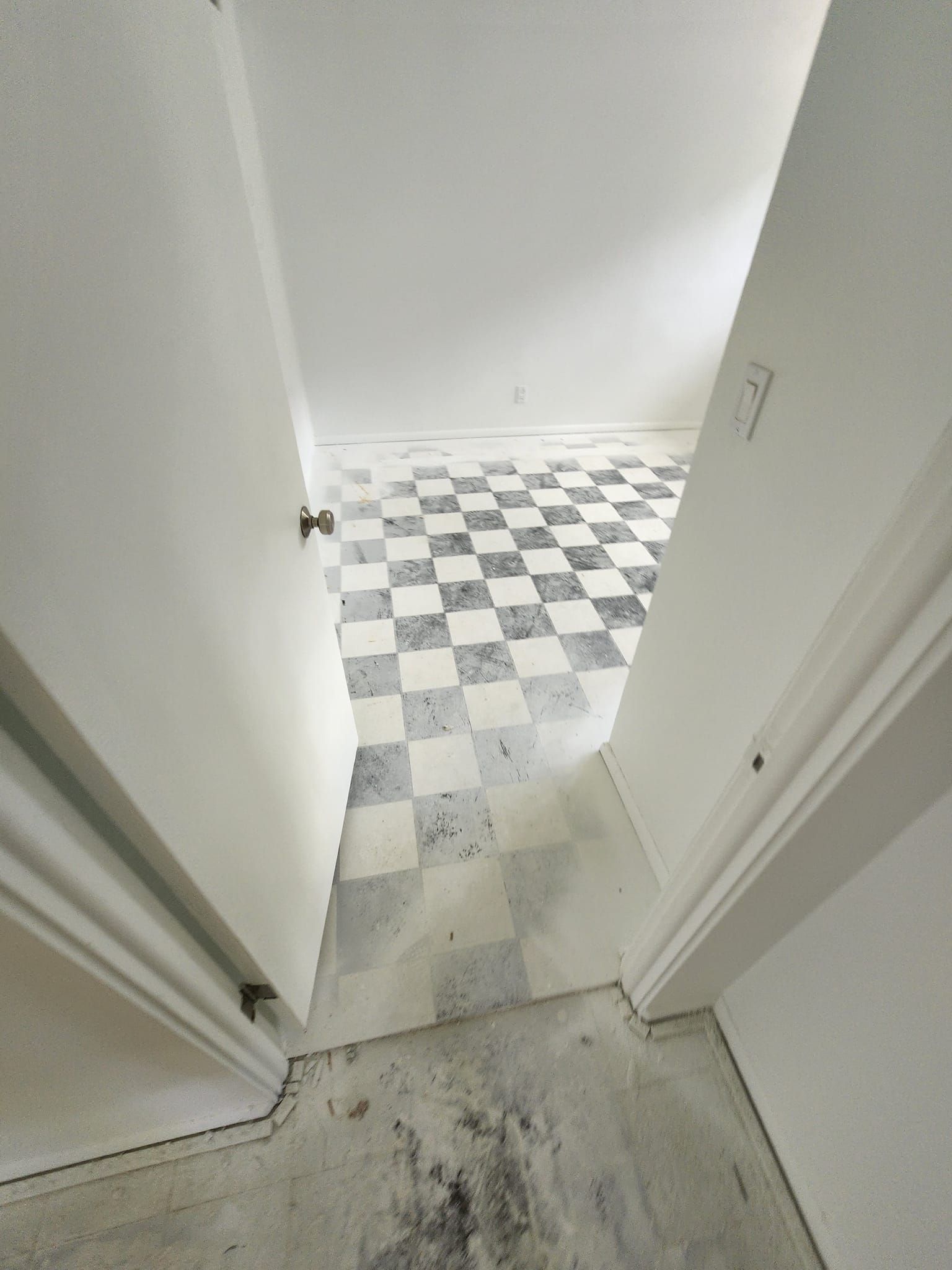 A room with a checkered floor and white walls