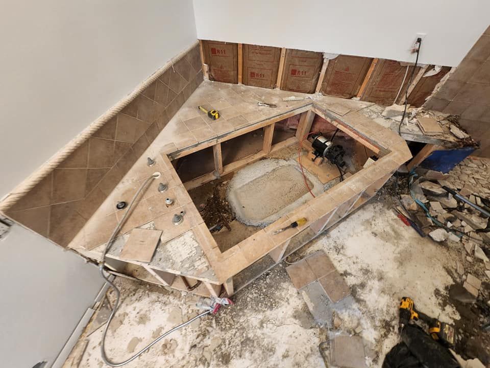 A bathtub is being built in the corner of a bathroom.