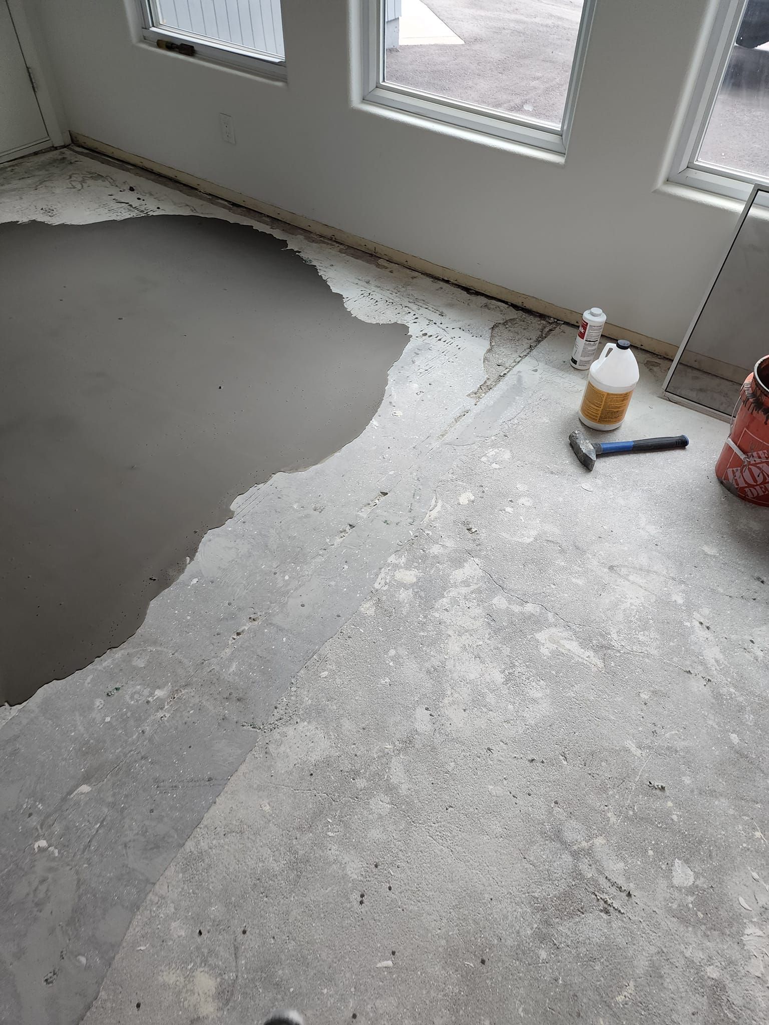 A room with a hole in the floor and a bottle of glue on the floor.