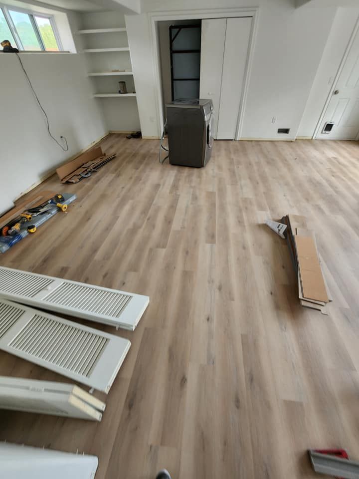 A room with a wooden floor and a washer and dryer in it.