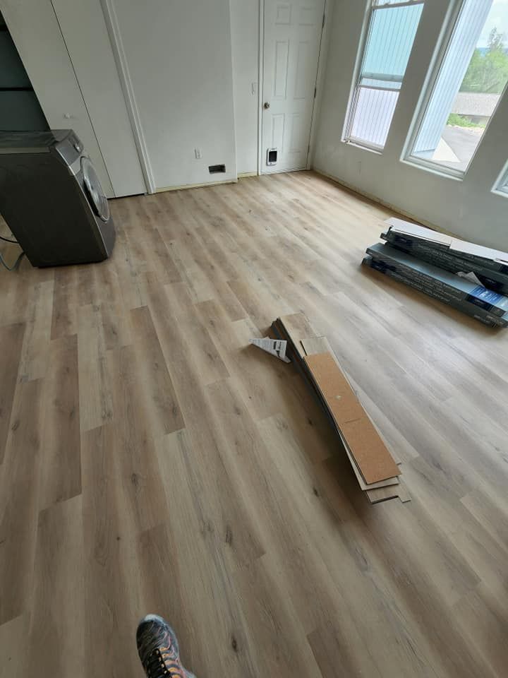 A person is standing on a wooden floor in a living room.