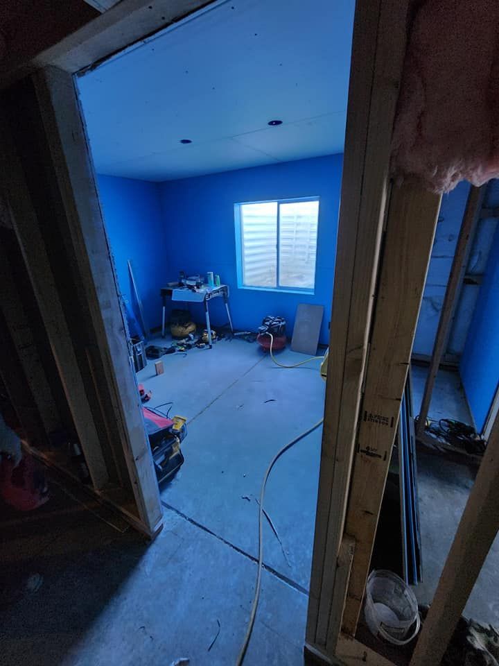 A room with blue walls and a window is being remodeled.