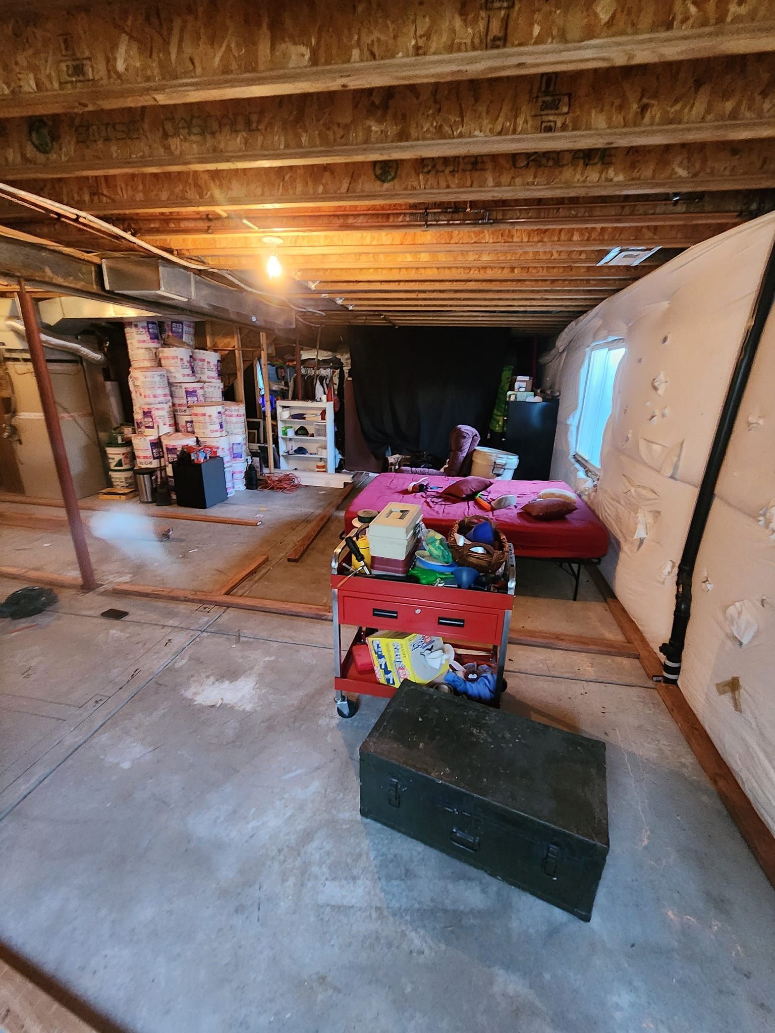 A room with a bed and a trunk in it.