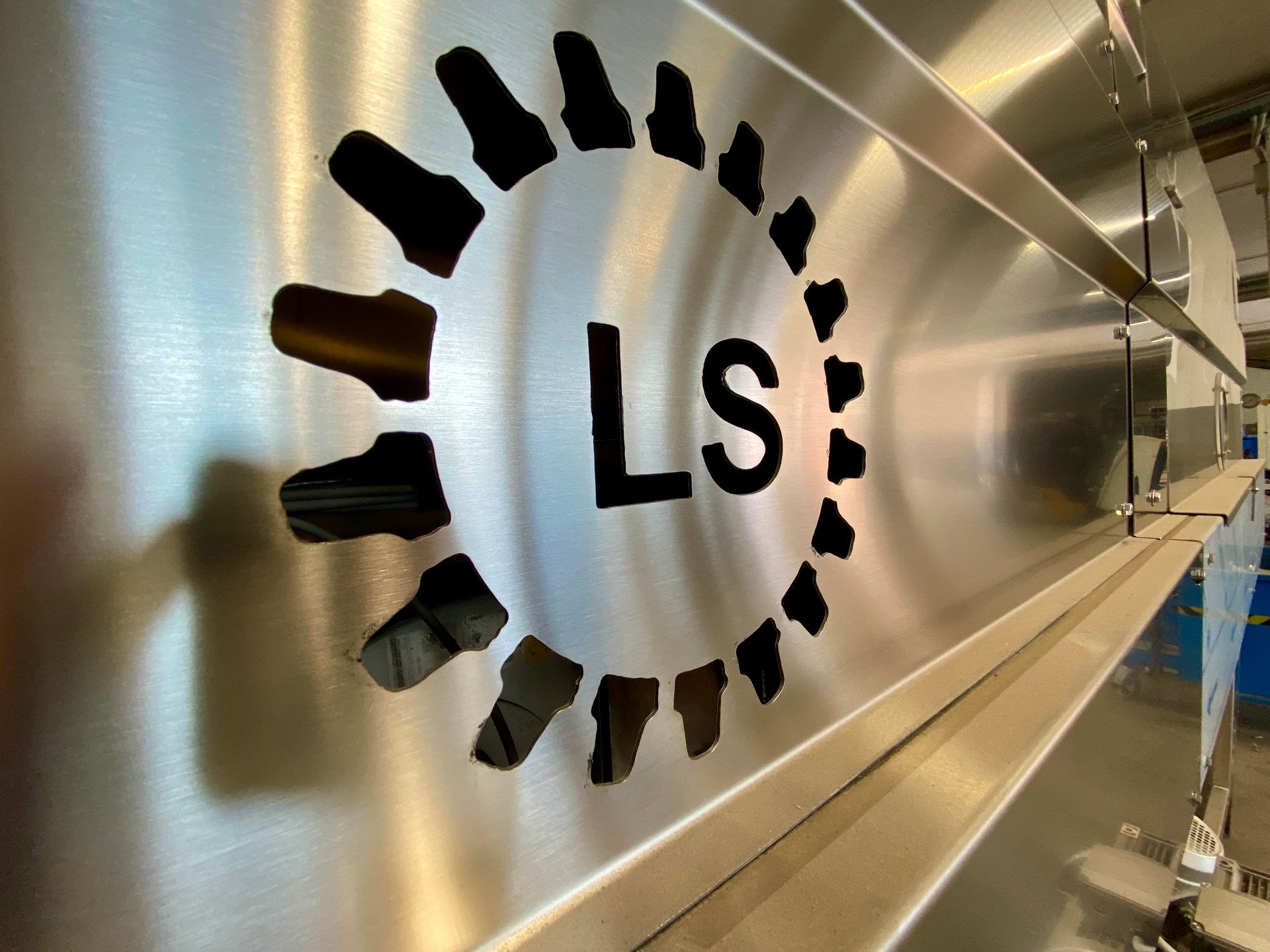 Logo LS su un pannello a parete argentato in un corridoio moderno