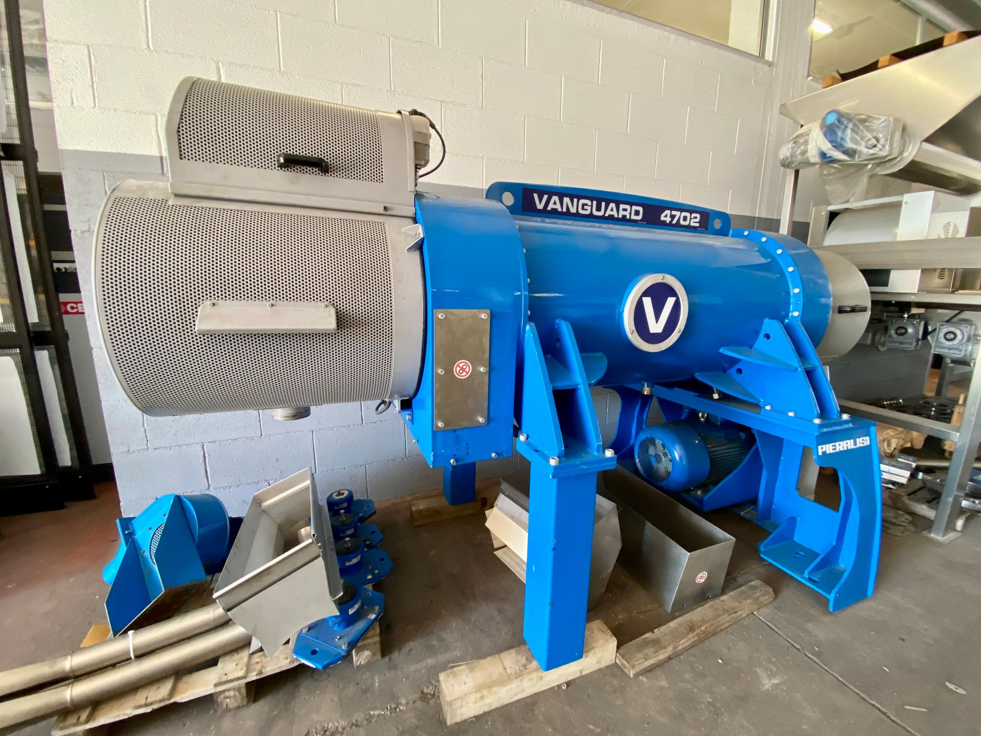 Macchina industriale blu con tubi metallici e motori in un ambiente di fabbrica