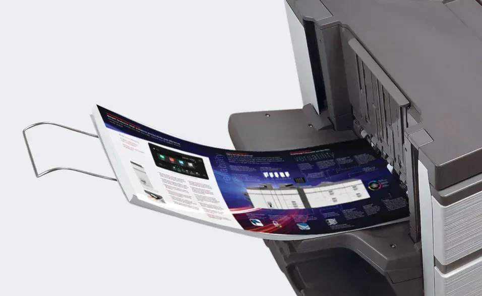 A printer outputting a large, color-printed document with a curved shape.