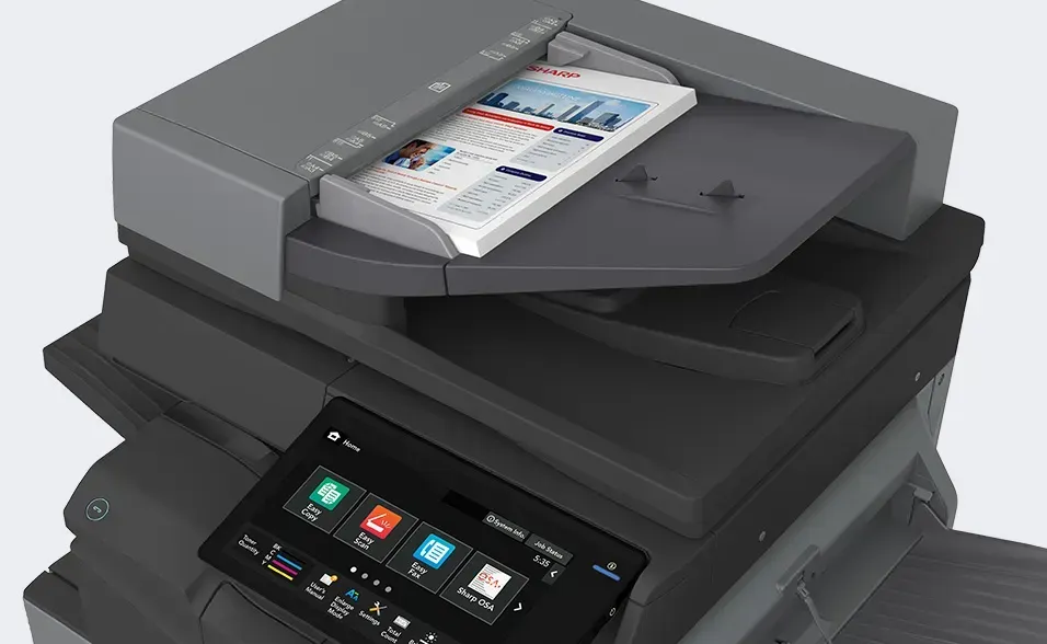 Smartphone near the control panel of a black and gray office copier.