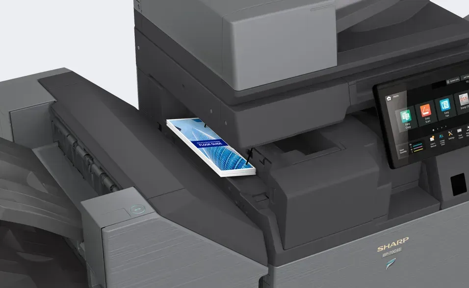 A smartphone resting on a black and gray office printer, likely for wireless printing.