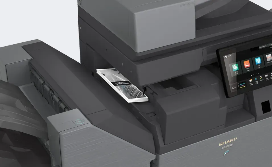 A gray Sharp printer with a document in the output tray. Touchscreen display on the right.