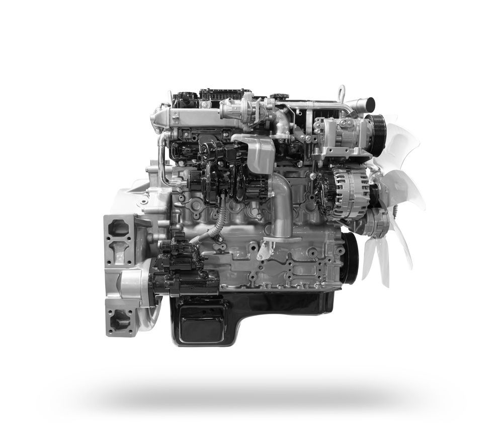 Black and white photo of a complex engine, likely for a vehicle, with various components and a fan on the right.