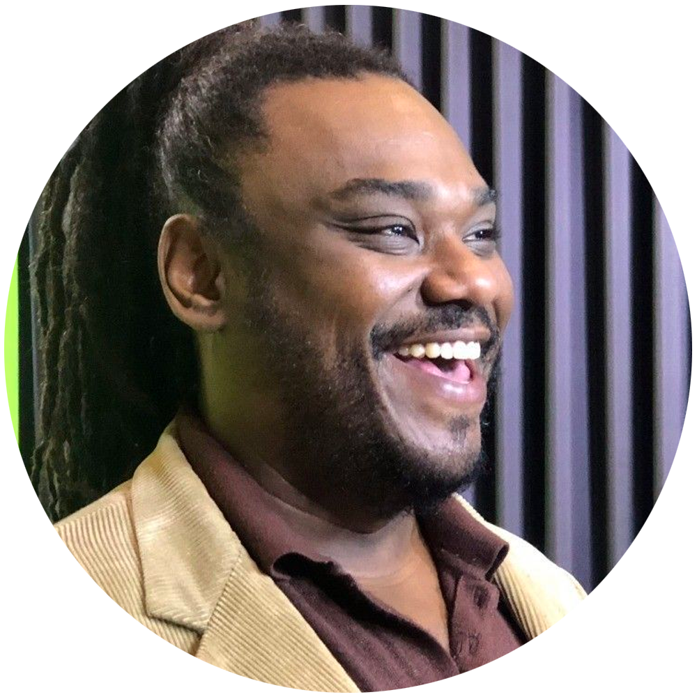 Um homem com dreadlocks está sorrindo em círculo