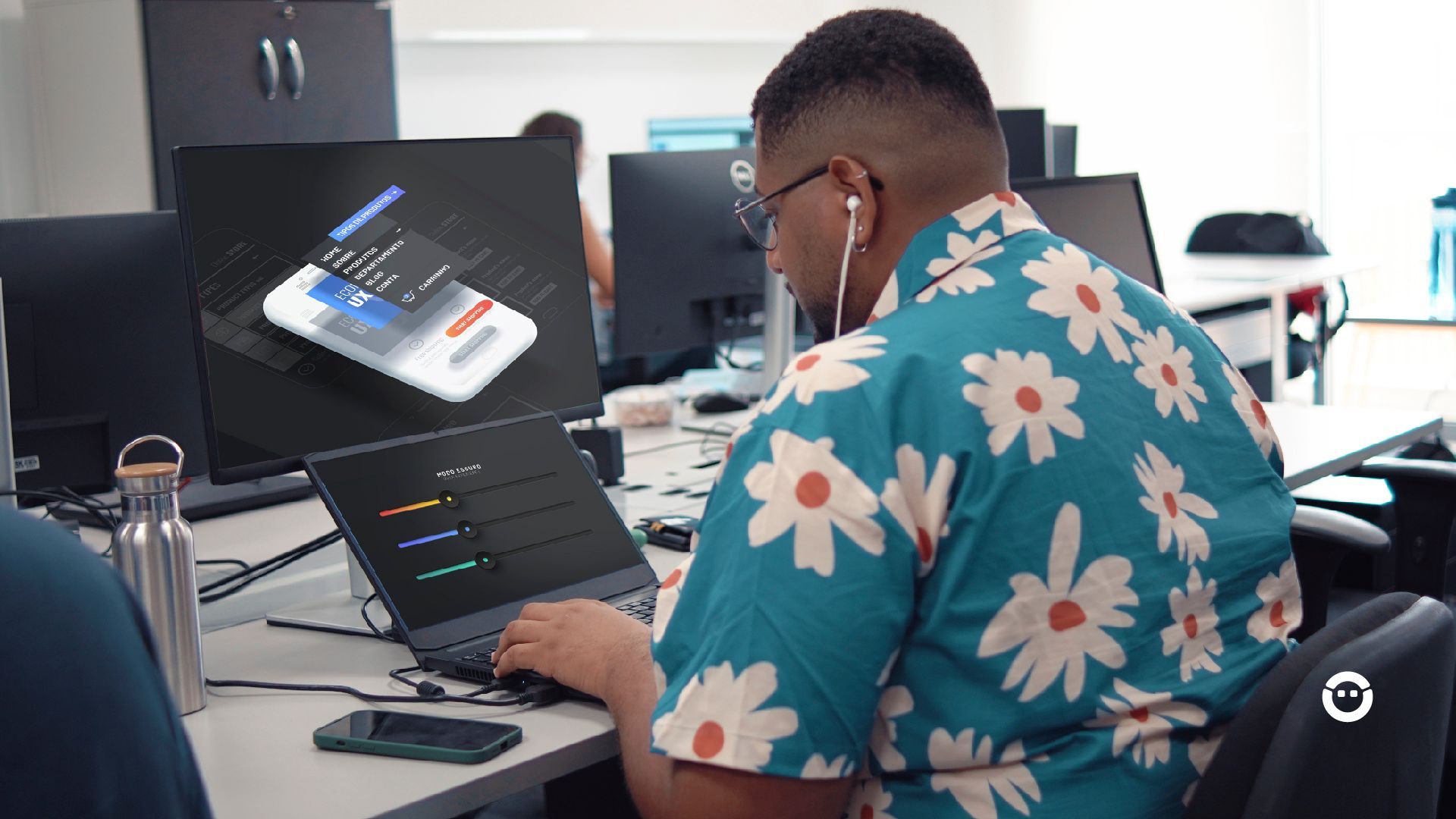 Um homem trabalhando com as cores no design e na experiência do usuário em um notebook.