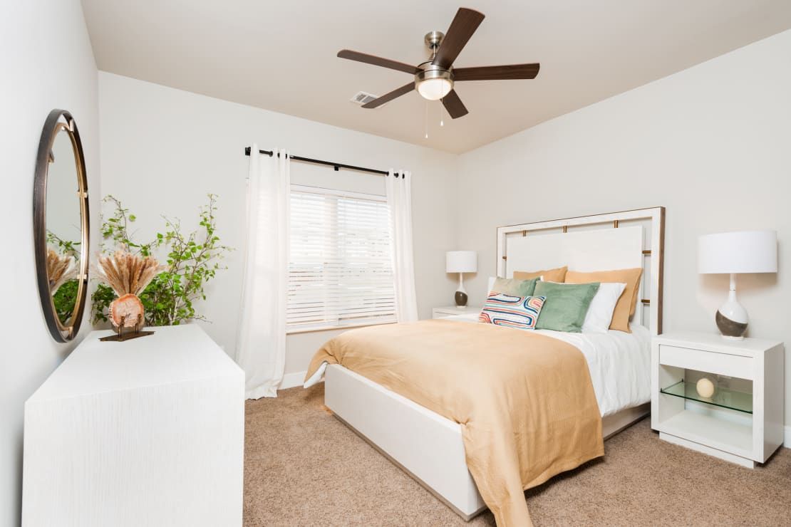 Bedroom with bed, white dresser, window, and brown ceiling fan.