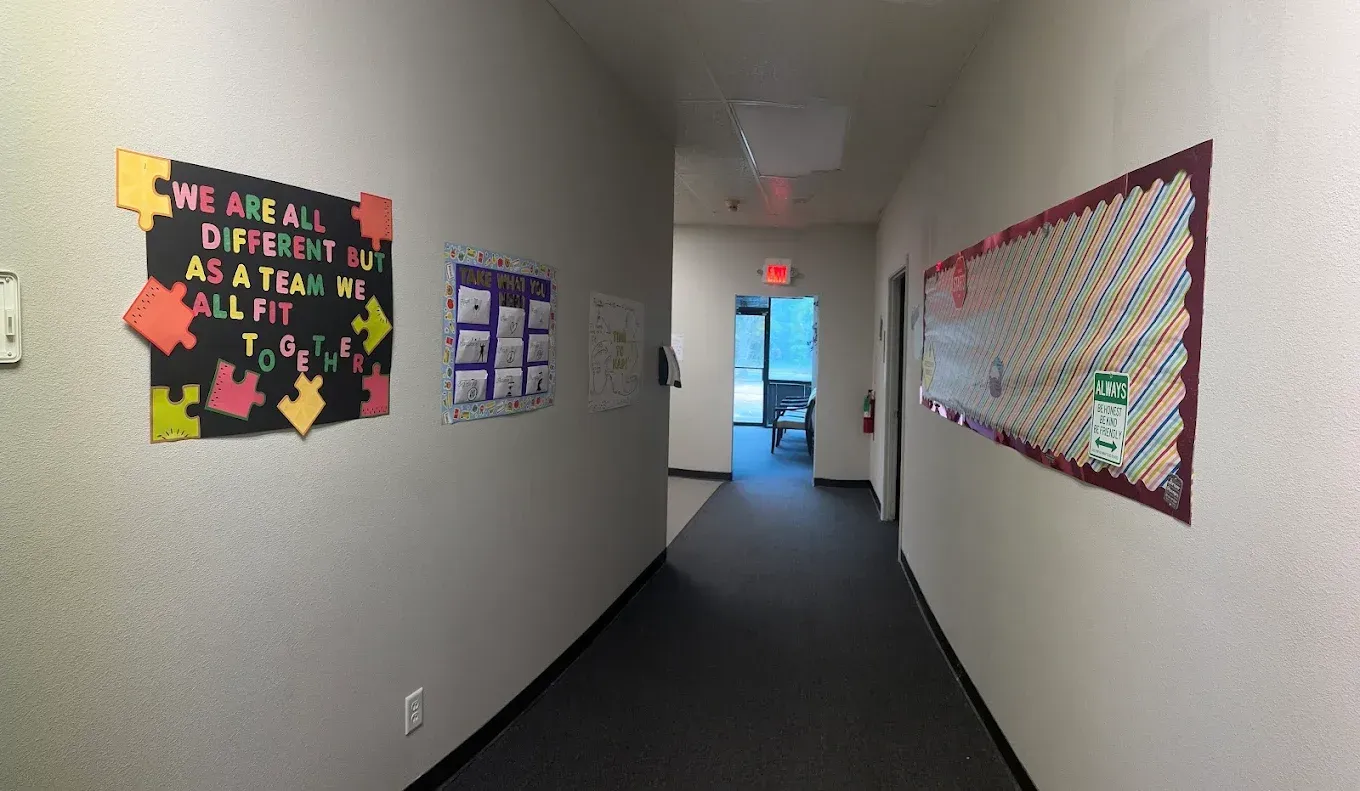 A hallway with a sign on the wall that says `` we are all different as a team we all fit ''.
