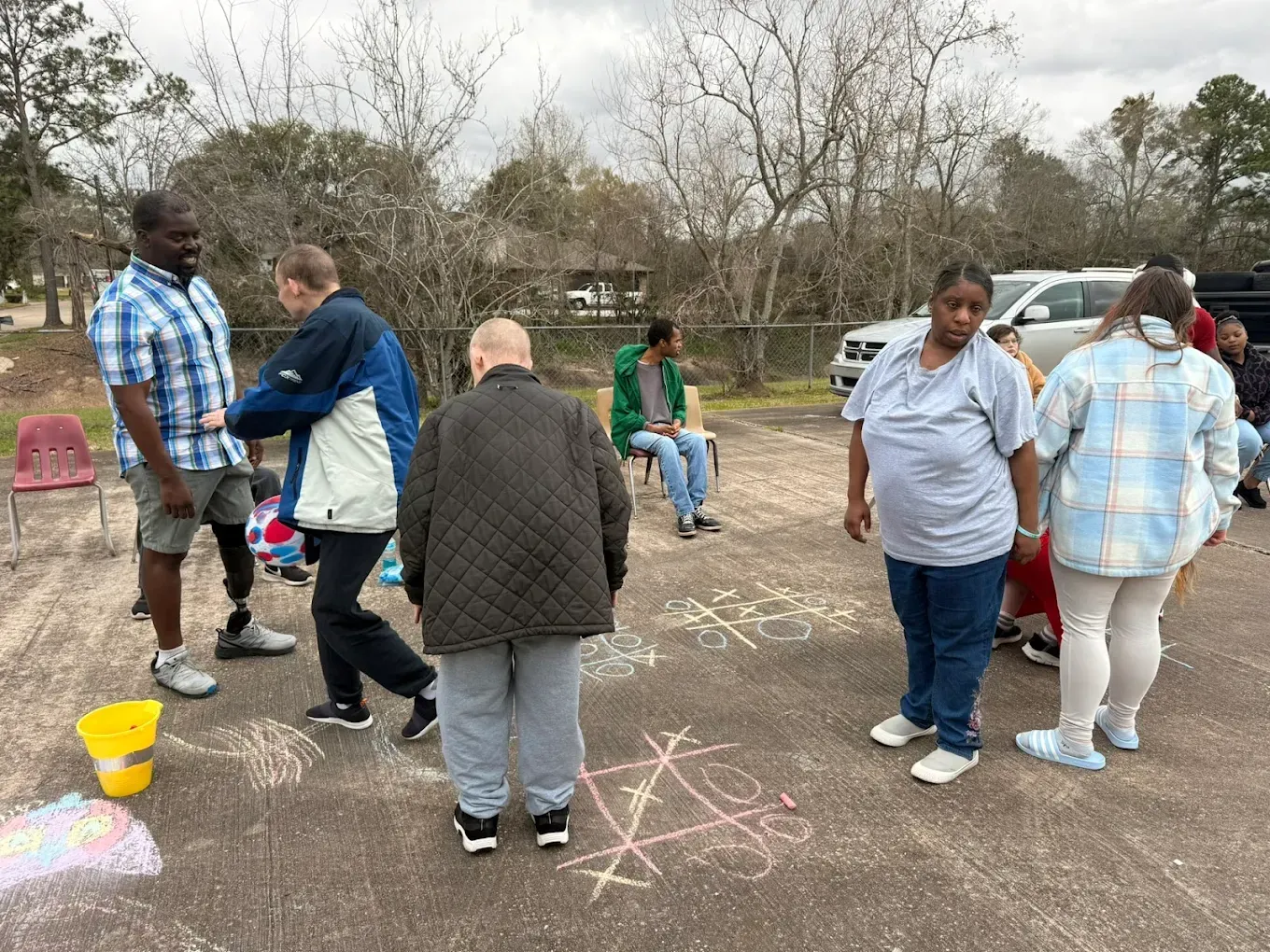 A group of people are standing in a parking lot.