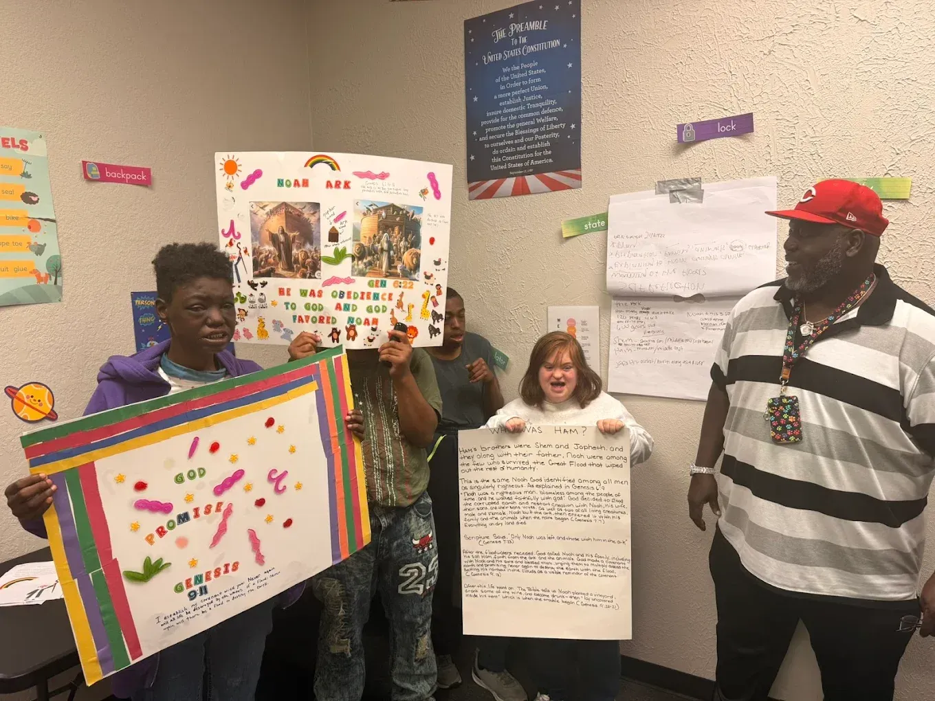 A group of people are standing in a room holding signs.