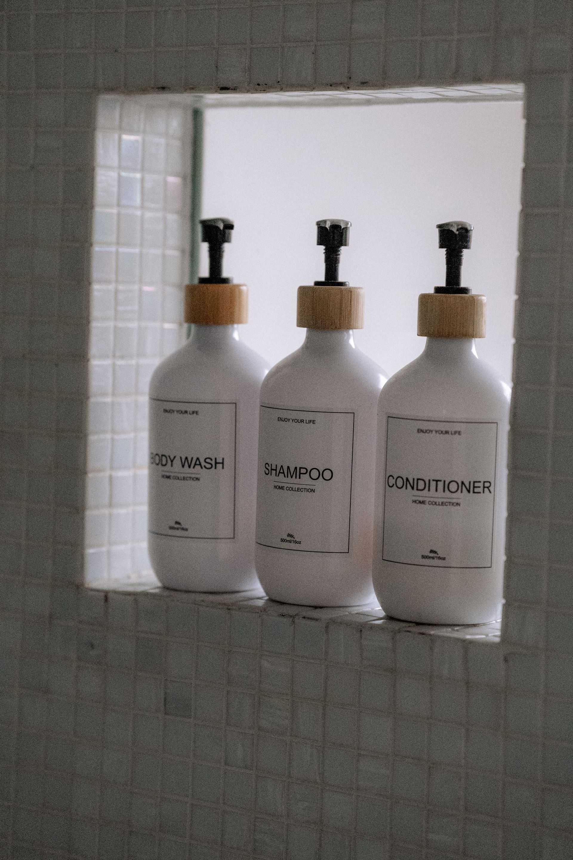 Drie witte flessen met zwarte pompjes, met de opschriften 