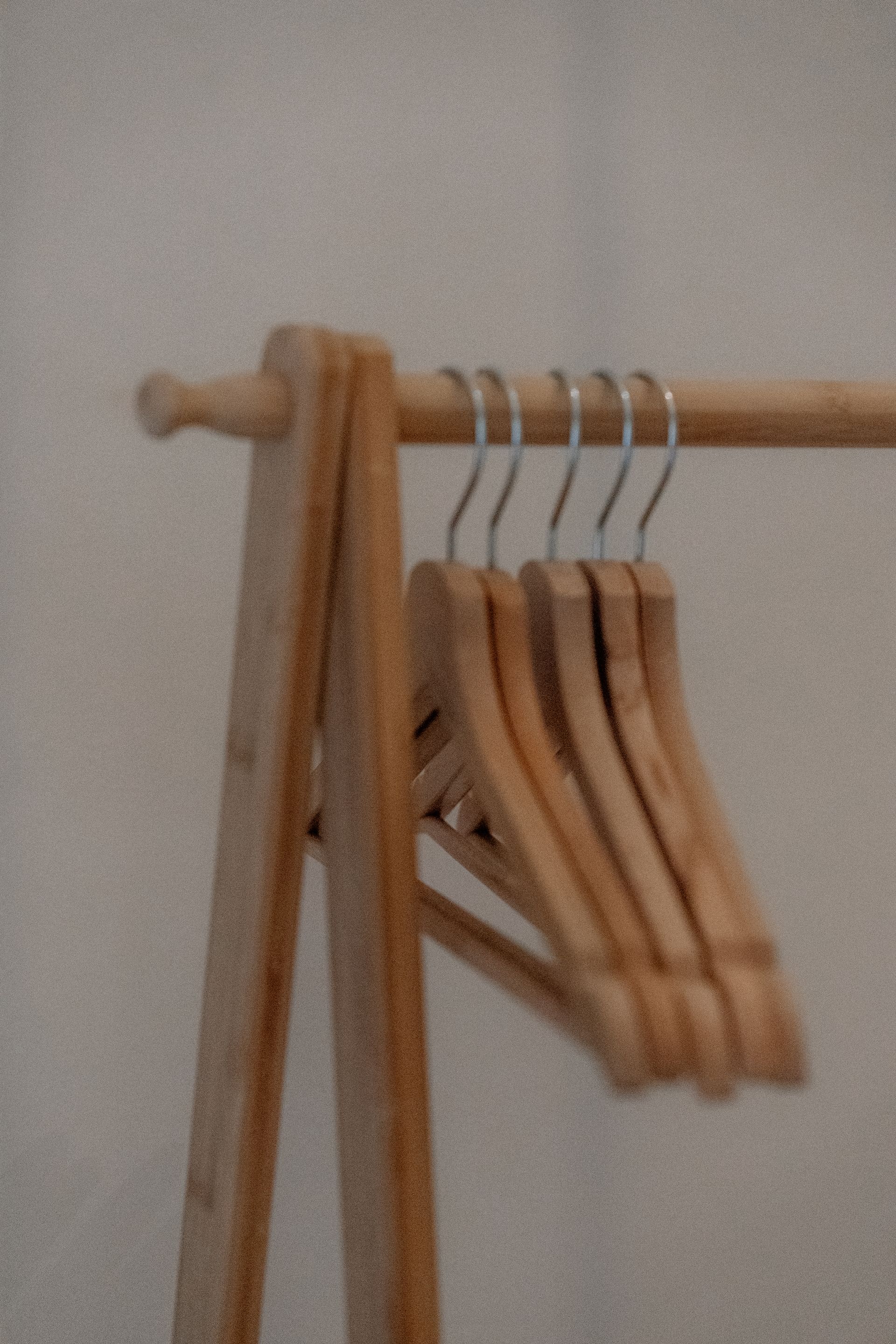 Houten kledingrek met diverse lege houten hangers.