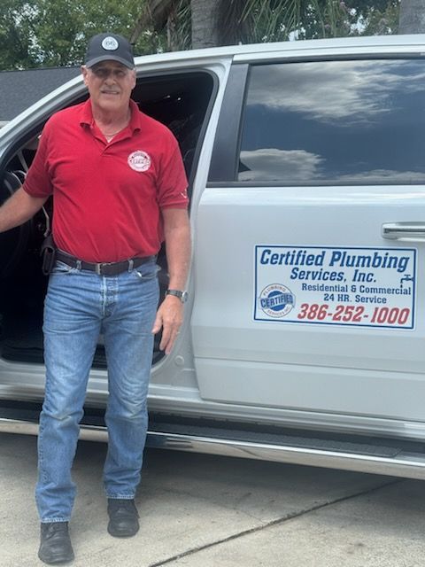 Man stepping out of a white pickup truck with a company logo on the door.