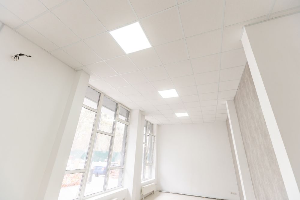 Bright white empty room with large windows and ceiling lights