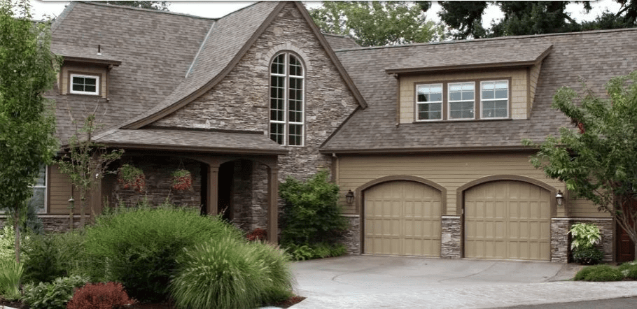 Brick suburban house with arched garage doors, front porch, and large windows
