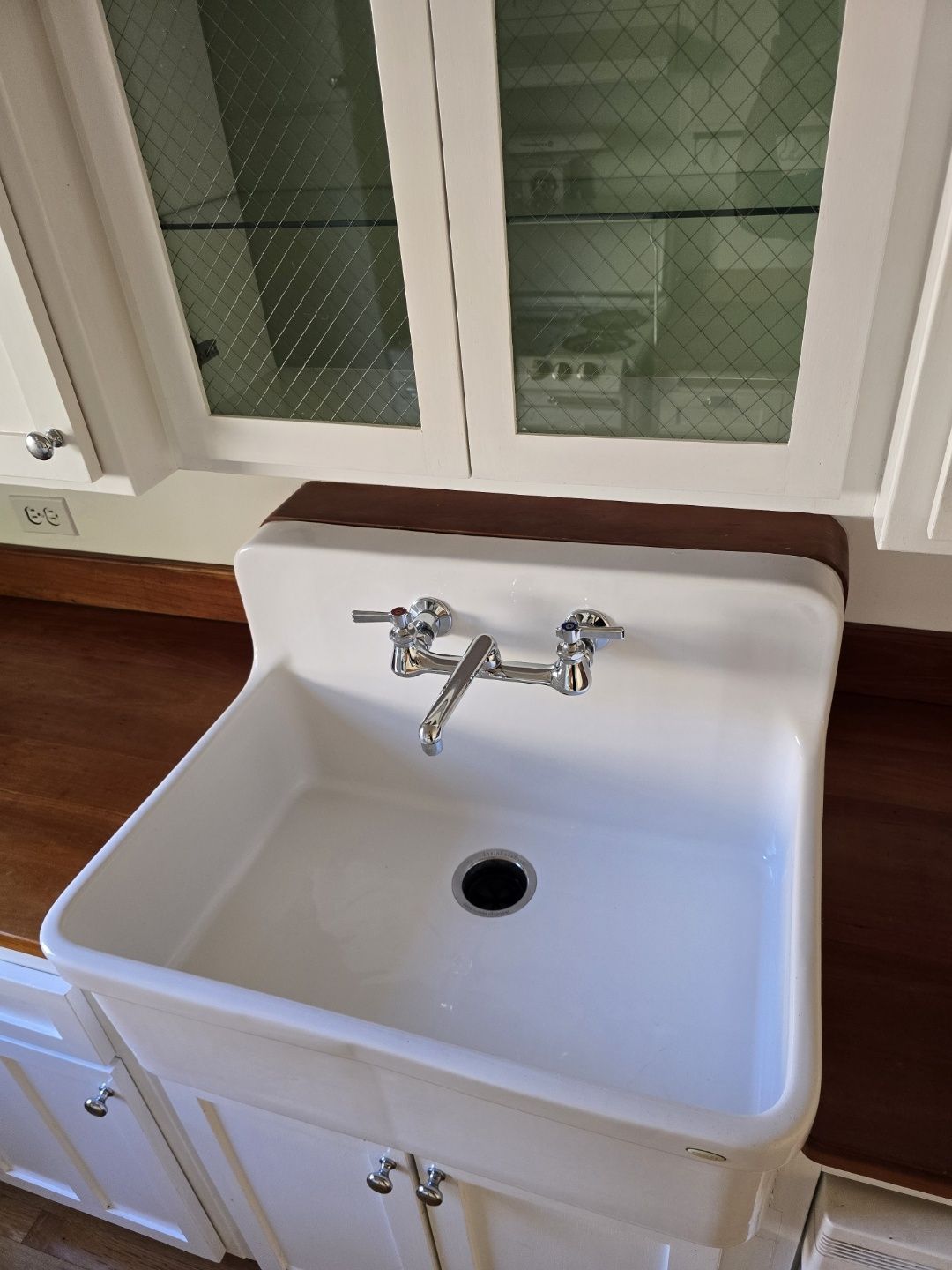A kitchen sink with a faucet and a drain in it