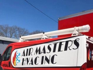 White HVAC service van with red cab and “AIRMASTERS HVAC INC” signage on the side and roof, outdoors under blue sky