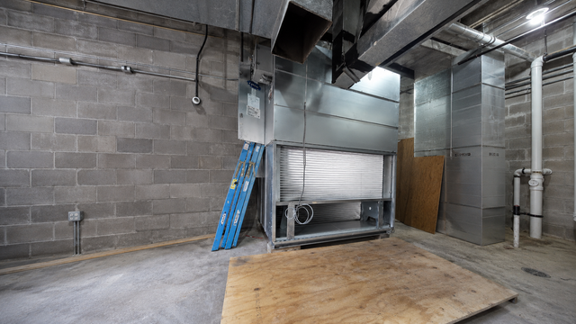 Worker installing HVAC ductwork in an unfinished wooden house frame