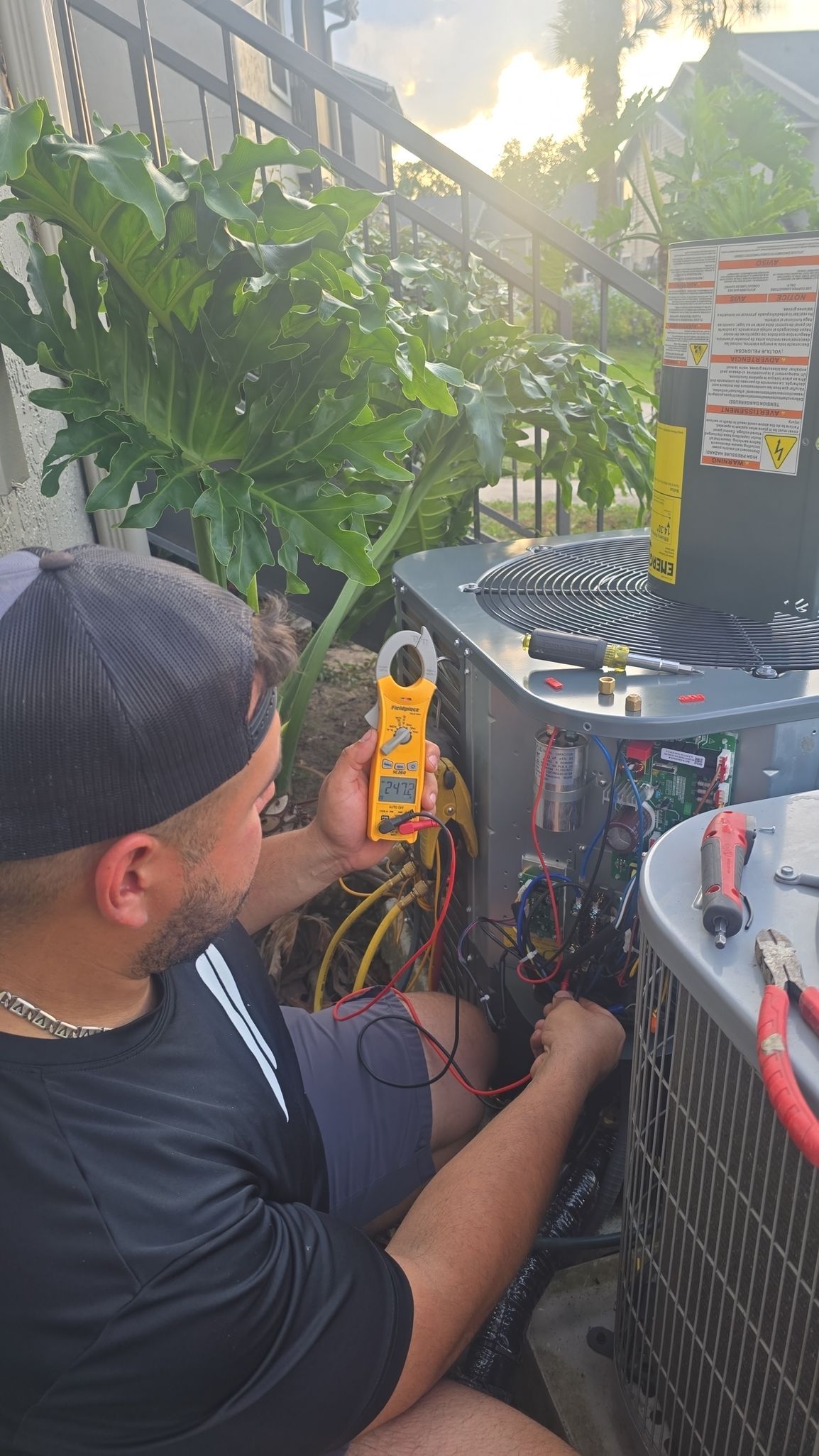 Technician checking a tablet beside an open service van stocked with tools and supplies