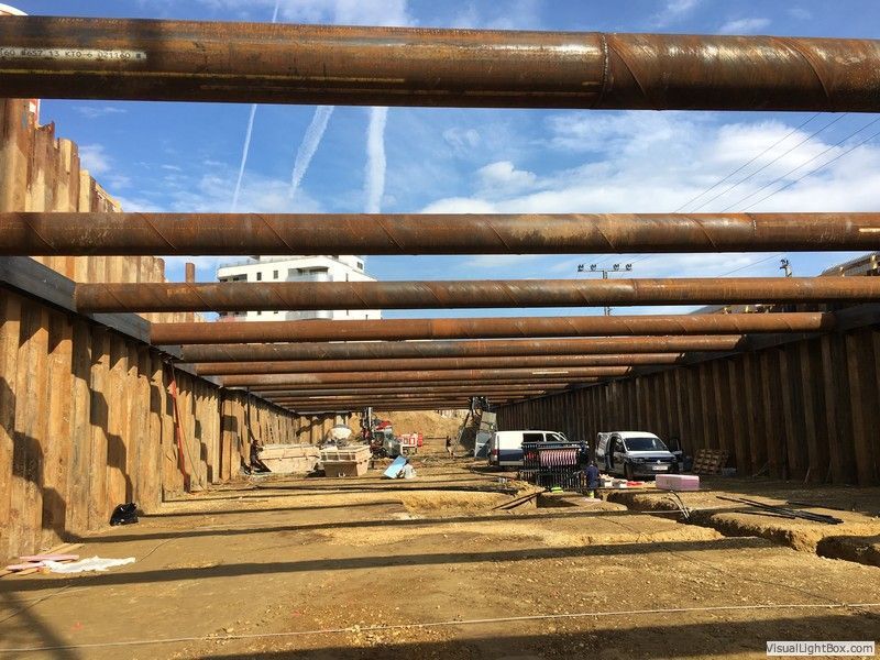 eine Baustelle mit vielen Metallrohren und einer Holzwand .