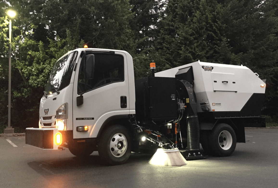 A Nebraska power sweeping truck in action on a clean urban street, highlighting professional street 