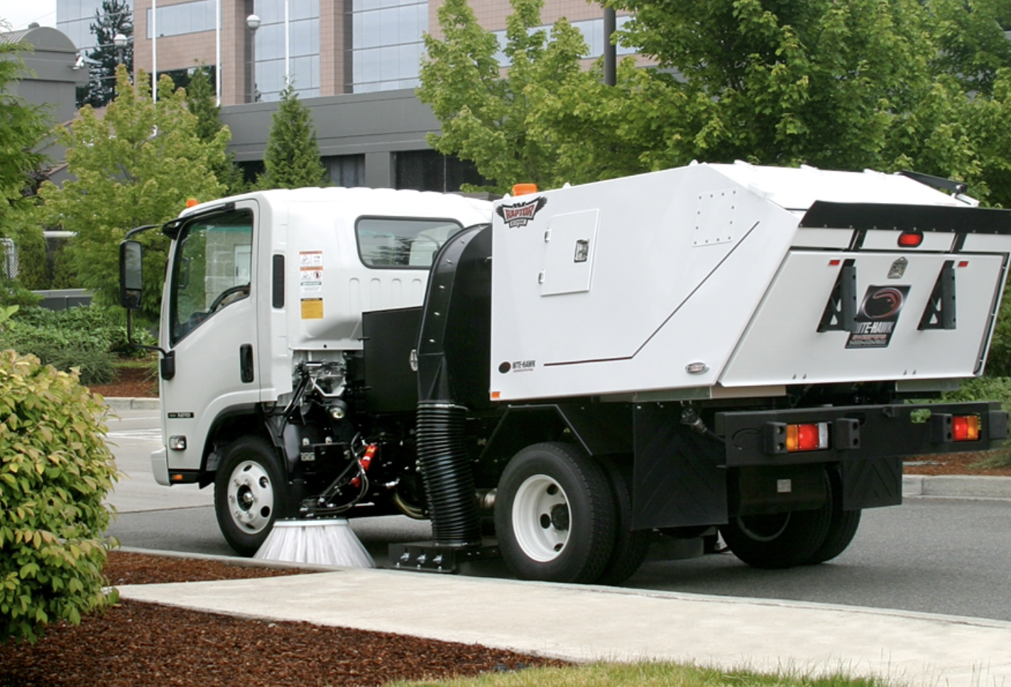 A Nebraska power sweeping truck in action on a clean urban street, highlighting professional street 