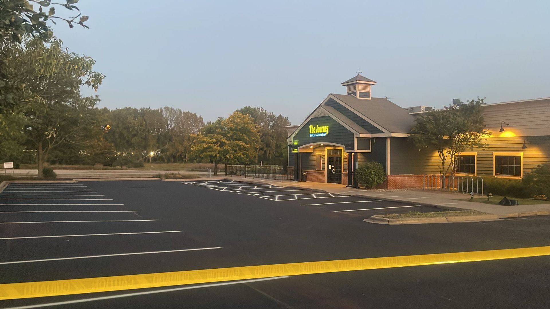Exterior of a building with a dark parking lot. The building has a sign that says 