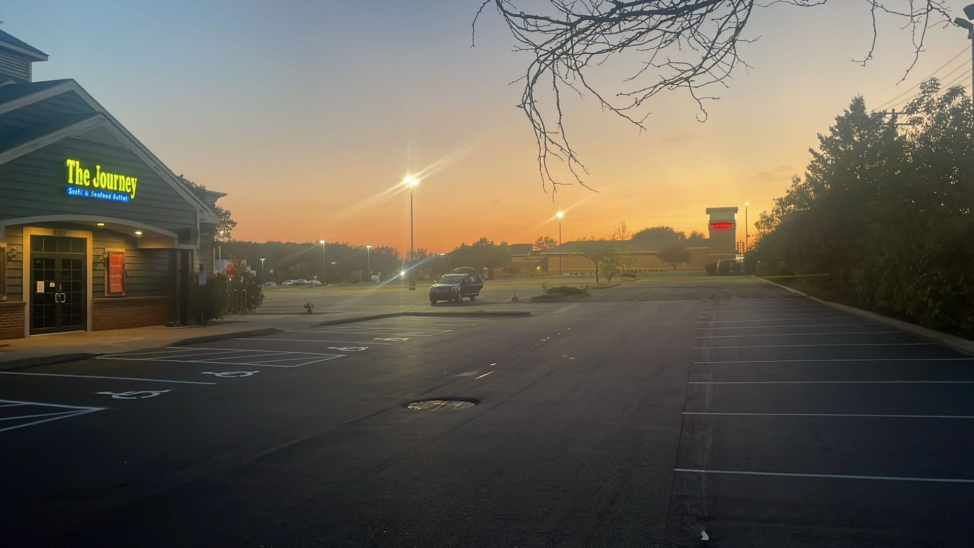 Restaurant exterior at dawn; empty parking lot; orange and blue sky.
