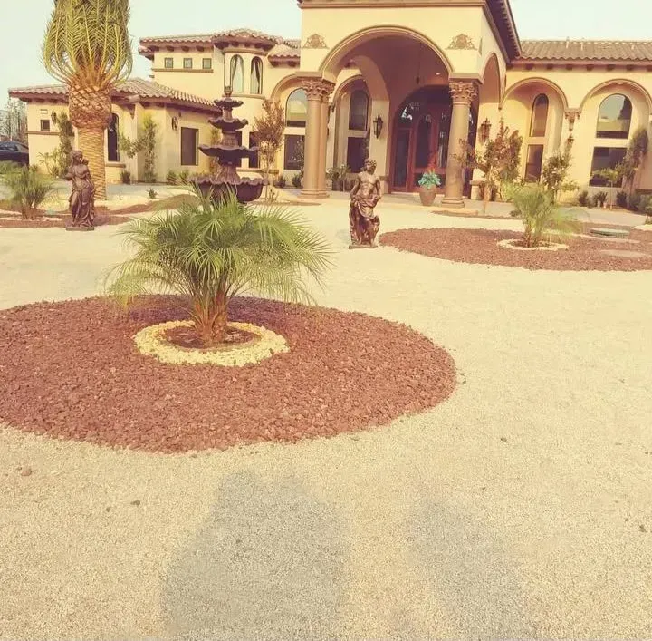 Large house with fountain, statues, and landscaping in front.