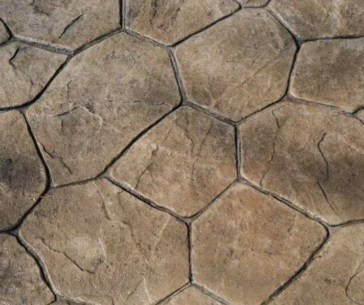 Close-up of stamped concrete patio with irregular stone pattern and dark grout.