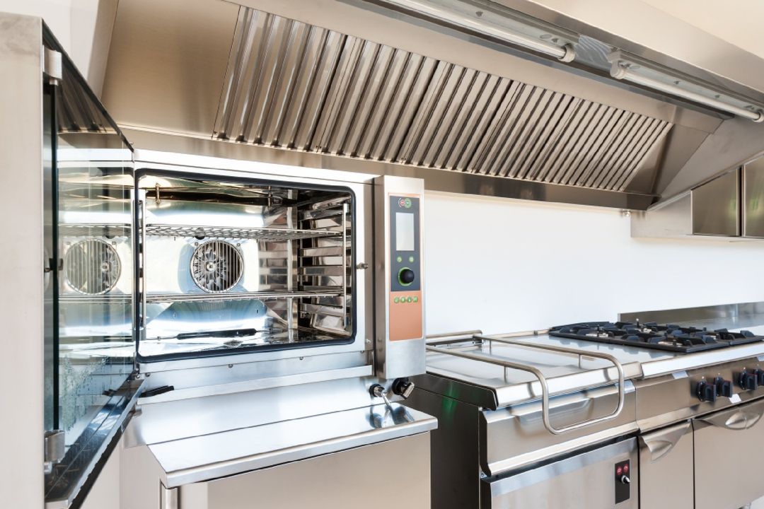 cucina industriale con forno e cappa in acciaio
