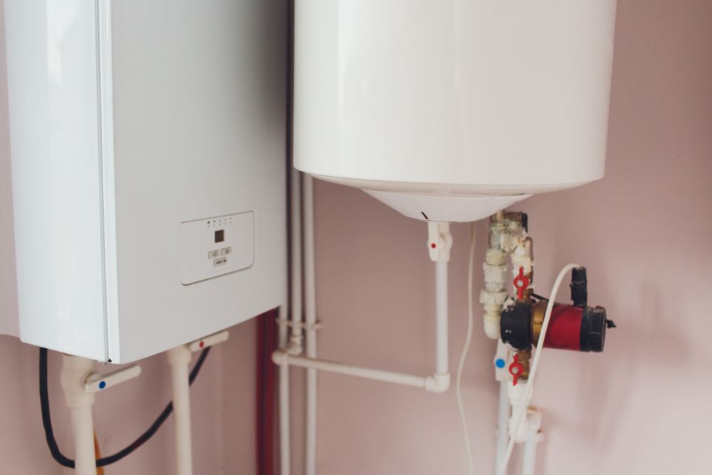 White Water Heater and Boiler With Associated Pipes and a Red Pump — Jade Fluerty Electrical In Tinana, QLD