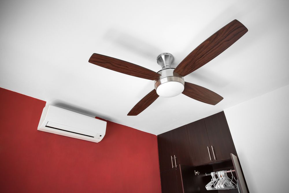 Ceiling Fan With Wooden Blades, Air Conditioner, and Red Wall in a Room — Jade Fluerty Electrical In Tinana, QLD