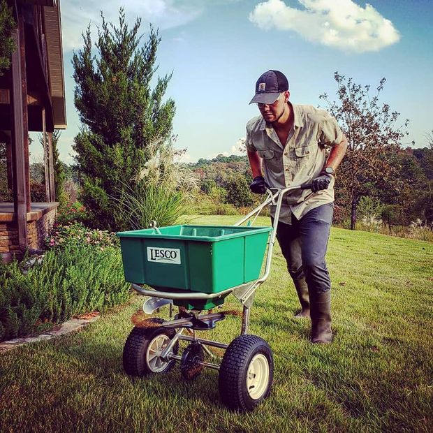 man fertilizing lawn in hot springs, ar