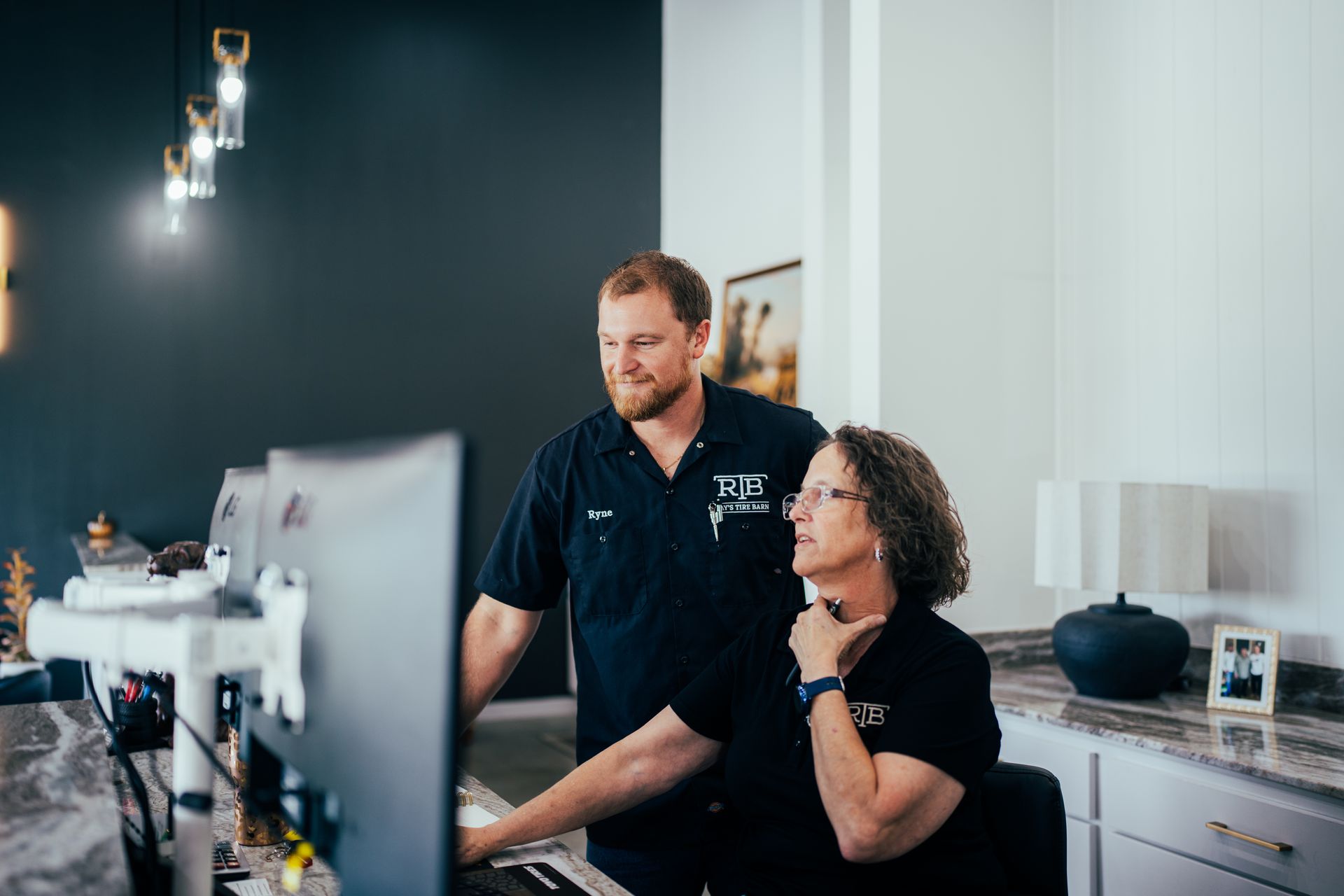 Man and woman looking at a computer screen in an office setting.